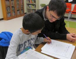 Student helping child in classroom 